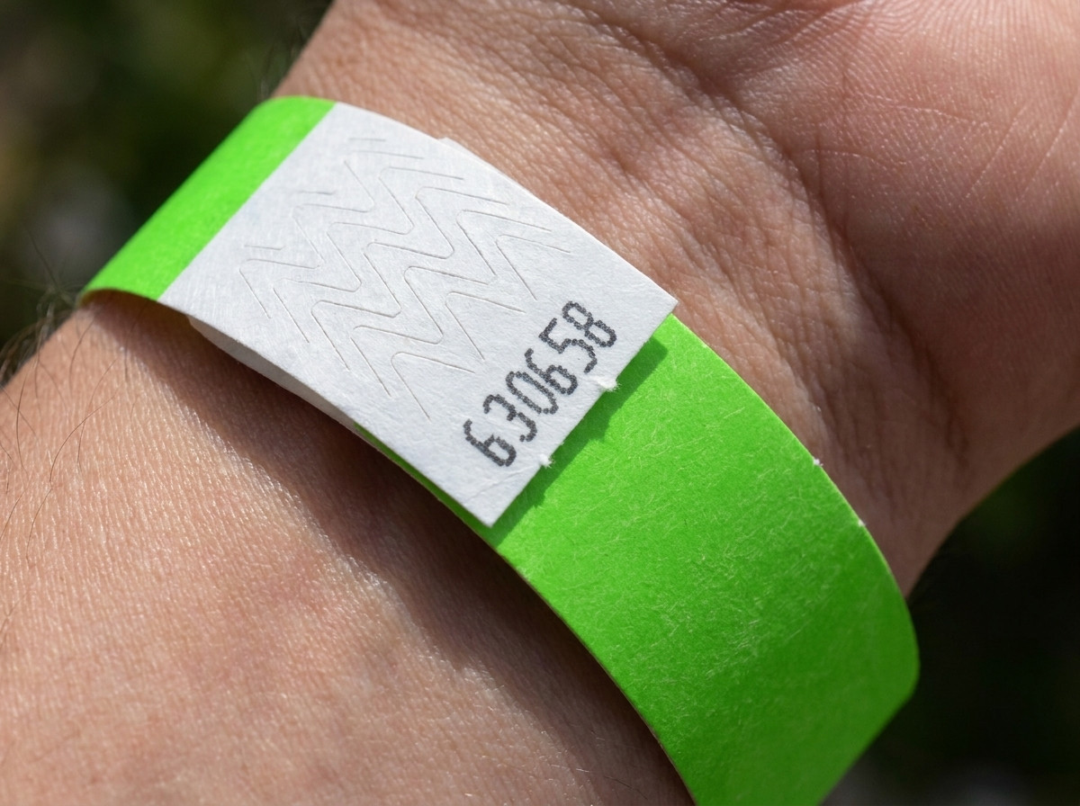 Gros plan sur la fermeture anti-transfert inviolable d'un bracelet identification numéroté, illustrant la résistance à la manipulation et à la réutilisation